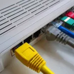 Home router with colourful network cables plugged into the back
