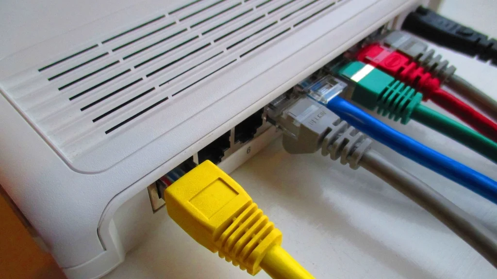 Home router with colourful network cables plugged into the back