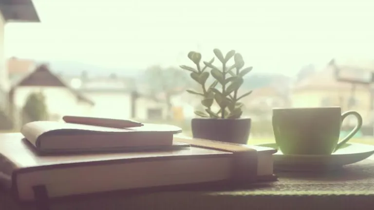 Notebook with a handwritten manga reading checklist next to a phone and manga volumes